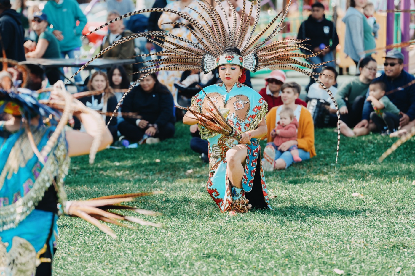 Native American dancer in full traditional regalia performing at the Good Neighbor Gathering